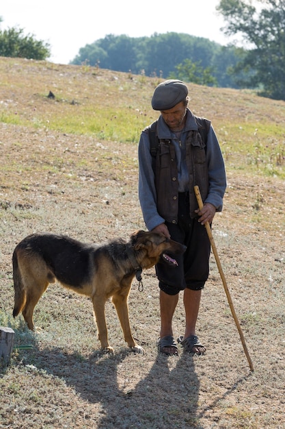 Retrato de um homem com um cão pastor de manhã cedo