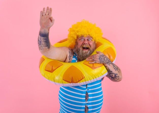 Foto retrato de um homem com um guarda-chuva de pé contra um fundo rosa