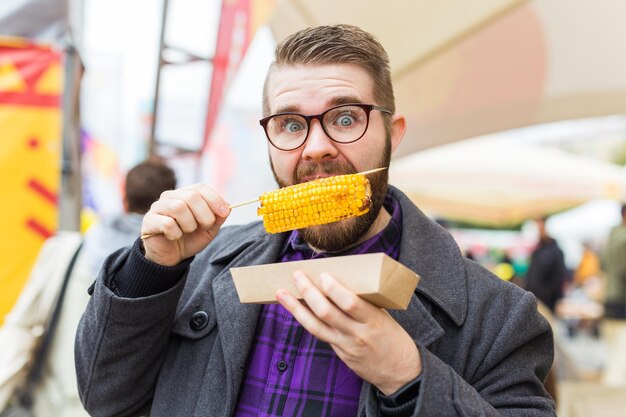 Foto retrato de um homem comendo milho ao ar livre