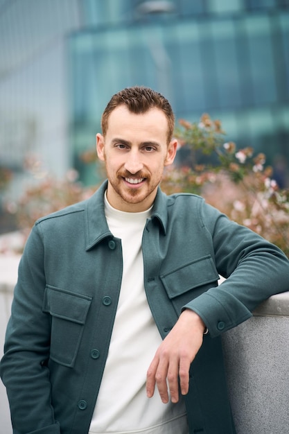 Retrato de um homem confiante sorridente posando para a câmera no distrito comercial