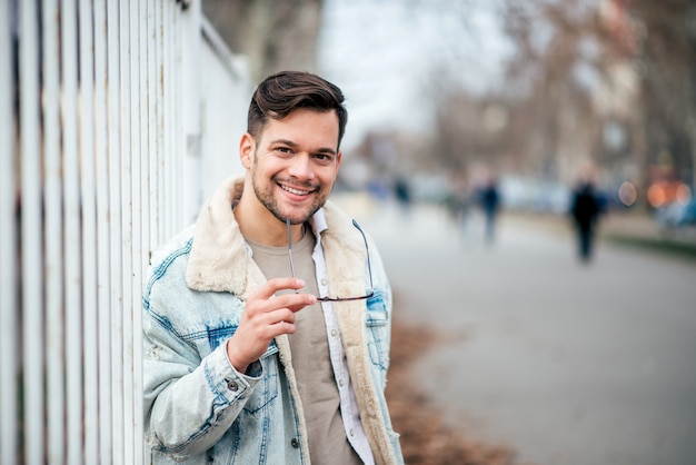 Retrato de um homem considerável novo no fundo urbano.