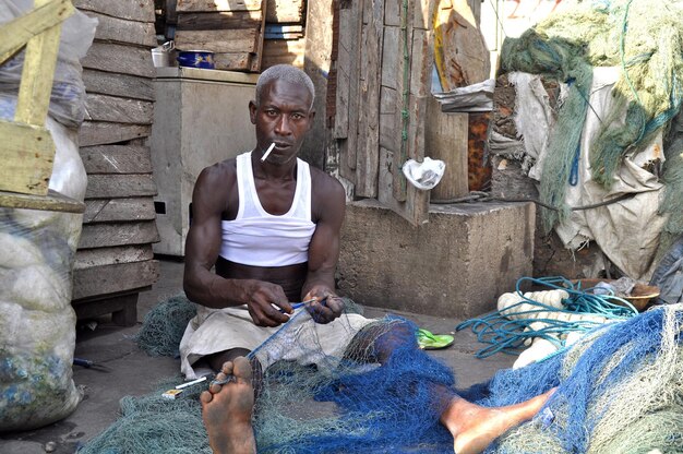 Foto retrato de um homem cortando uma rede de pesca