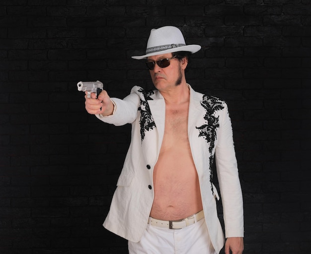 Foto retrato de um homem criminoso em uma jaqueta branca com pistolas