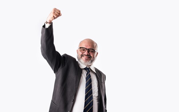 Retrato de um homem de negócios sênior indiano asiático desfrutando ou comemorando o sucesso, gritando ou com o símbolo de polegar para cima contra o branco isolado