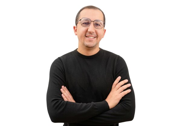 Retrato de um homem de óculos e uma camisola preta com os braços cruzados olhando para a câmera em um branco