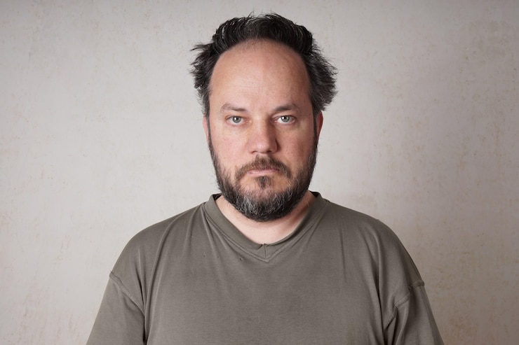 Foto retrato de um homem de pé contra a parede