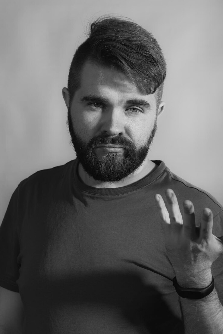 Foto retrato de um homem de pé contra um fundo cinzento