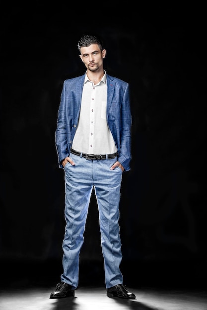 Retrato de um homem de pé contra um fundo preto