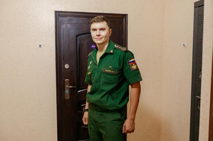 Foto retrato de um homem de uniforme de pé contra a porta