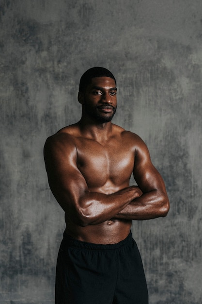 Foto retrato de um homem desportivo musculoso em topless com o braço cruzado