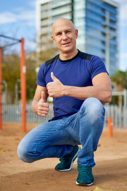 Retrato de um homem desportivo no parque infantil.