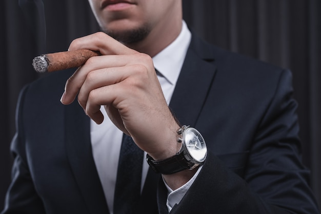 Retrato de um homem elegante de terno com um charuto. conceito de negócios. mídia mista