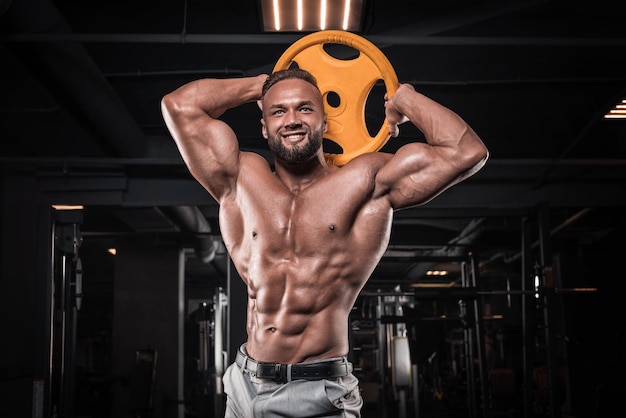 Foto retrato de um homem elegante, exercitando-se no ginásio. conceito de negócios e musculação. atividades esportivas. mídia mista