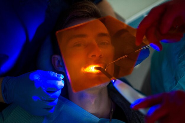 Foto retrato de um homem enquanto os dentistas operam na clínica