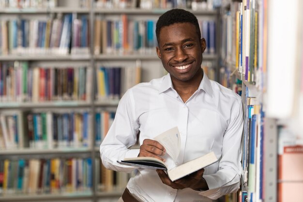 Retrato de um homem estudante universitário na biblioteca Profundidade de campo rasa