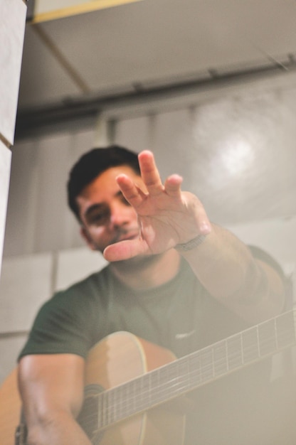 Foto retrato de um homem fazendo gestos enquanto segura uma guitarra