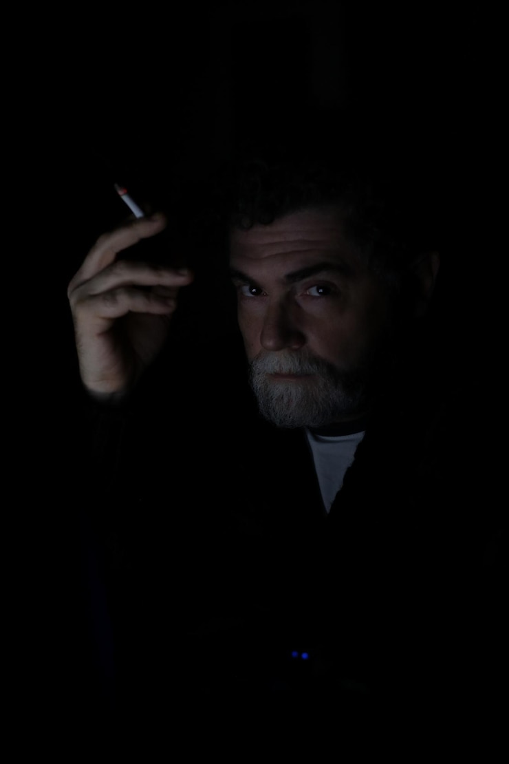 Foto retrato de um homem fazendo rosto contra um fundo preto