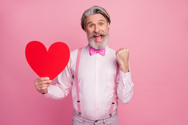 Retrato de um homem feliz e alegre segurando um grande coração grande