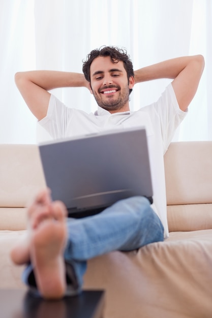 Retrato de um homem feliz usando um laptop