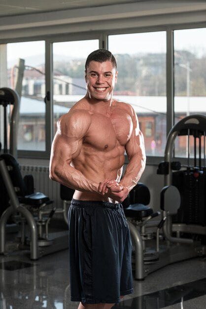 Retrato de um homem fisicamente apto, mostrando seu corpo bem treinado na academia