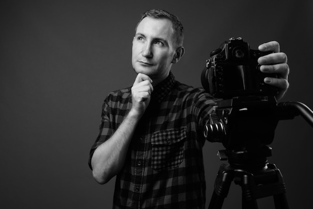 Foto retrato de um homem fotografando contra um fundo preto