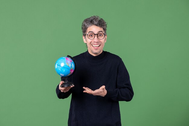 retrato de um homem gênio segurando um pequeno globo terrestre estúdio tiro fundo verde espaço natureza planeta professor