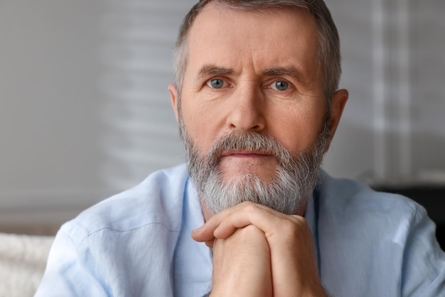 Retrato de um homem idoso bonito em casa