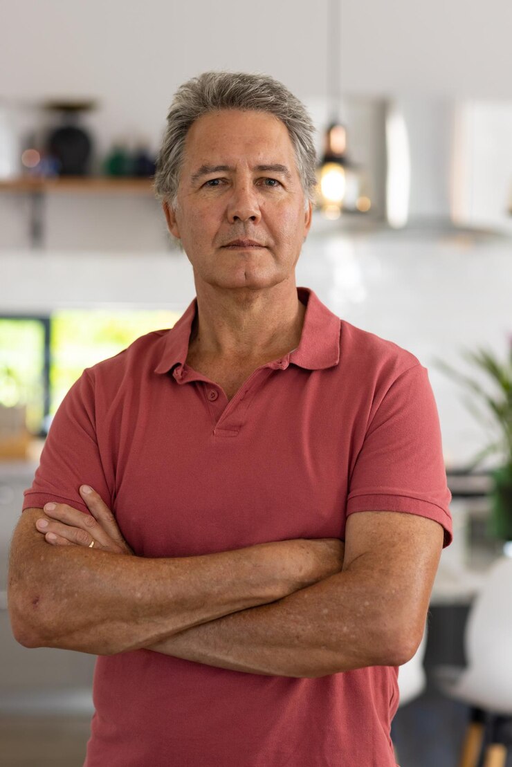 Foto retrato de um homem idoso caucasiano sério com os braços cruzados de pé em casa, espaço de cópia