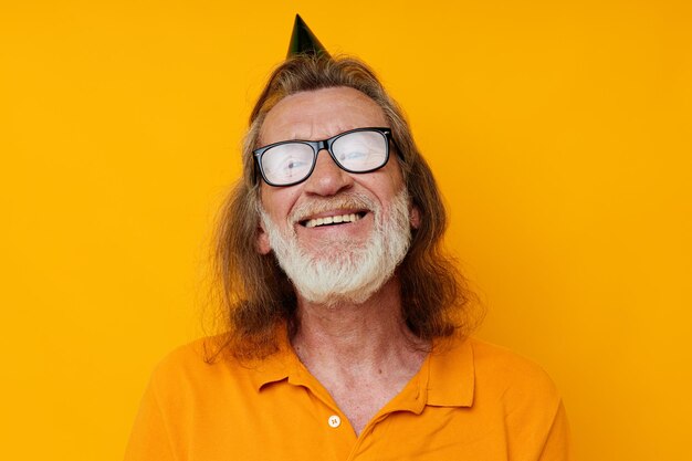 Foto retrato de um homem idoso em uma camiseta amarela com um boné na cabeça divertida vista cortada