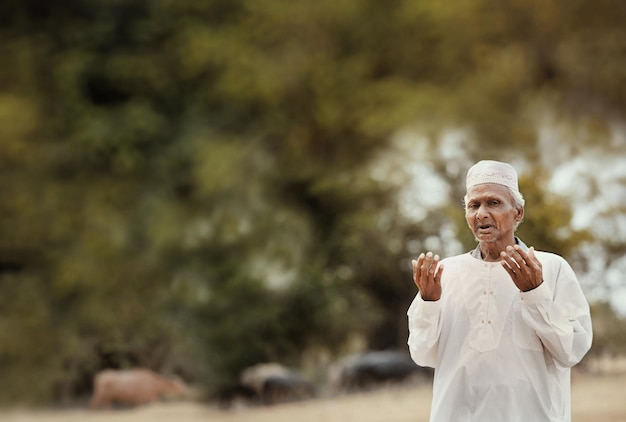 Foto retrato de um homem idoso fazendo gestos enquanto está de pé ao ar livre
