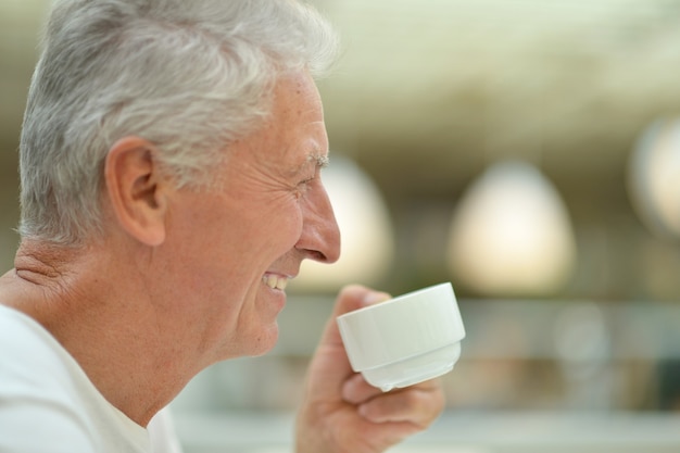 Retrato de um homem idoso feliz bebendo chá