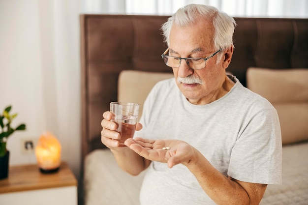 Foto retrato de um homem idoso tomando seus comprimidos