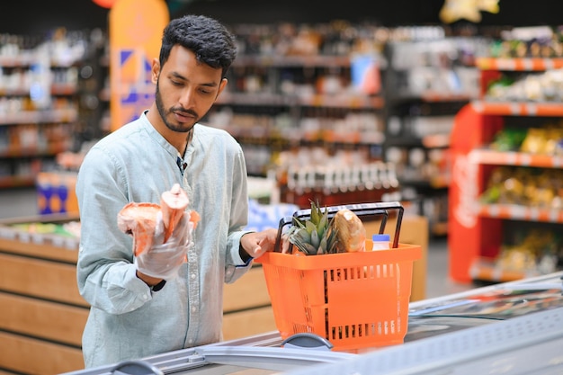 Retrato de um homem indiano comprando em uma mercearia Comprando mercearia para casa em um supermercado