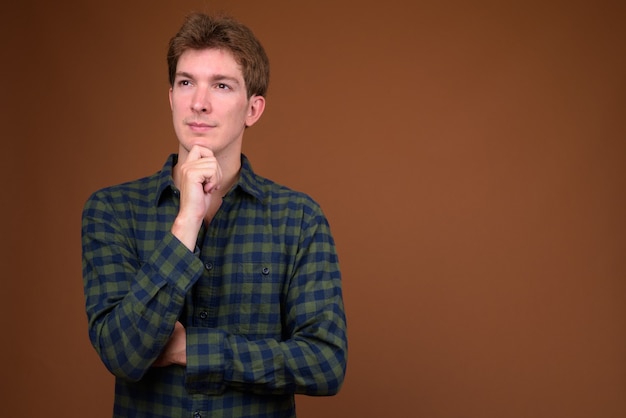 Retrato de um homem jovem e bonito hippie com camisa quadriculada verde