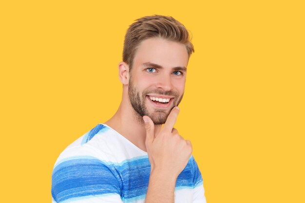 Retrato de um homem millennial feliz e elegante isolado em fundo amarelo