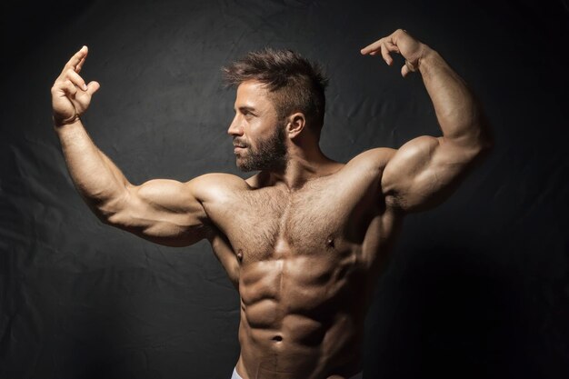 Foto retrato de um homem musculoso contra fundo preto