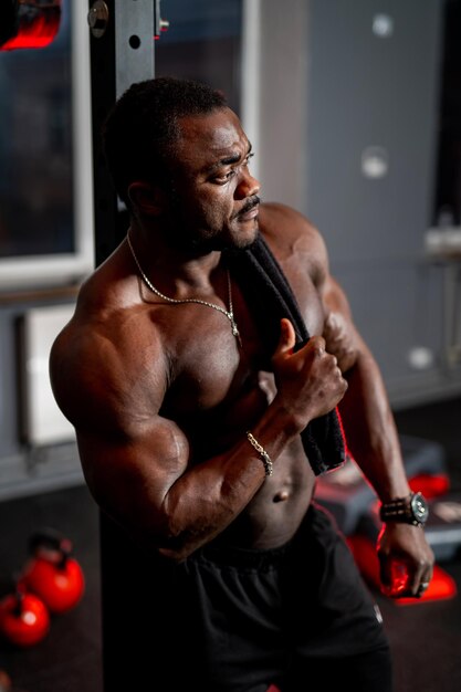 Retrato de um homem musculoso sem camisa após treino pesado Feliz fisiculturista posa para a câmera