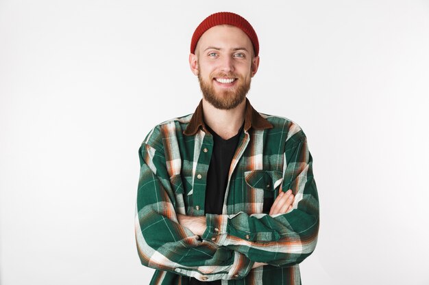 Retrato de um homem satisfeito, usando chapéu e camisa xadrez, sorrindo com os braços cruzados, isolado sobre um fundo branco