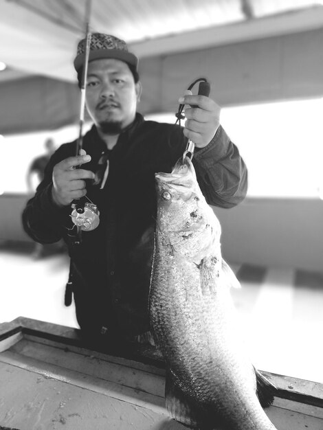 Foto retrato de um homem segurando um peixe