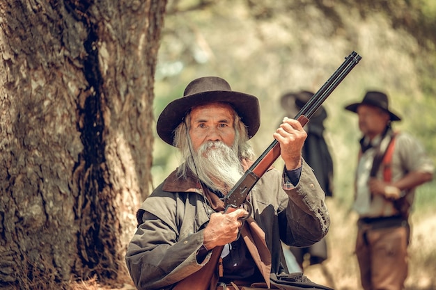 Retrato de um homem segurando um rifle