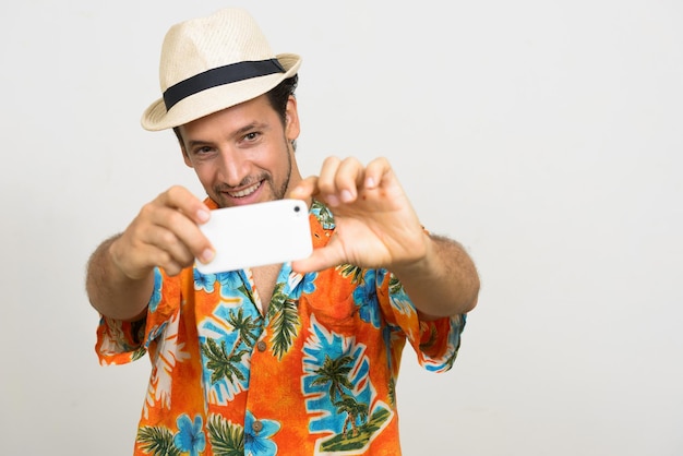 Foto retrato de um homem segurando um telefone celular contra um fundo branco