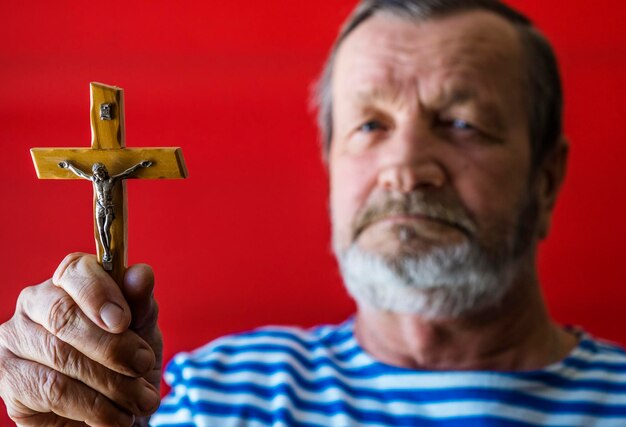 Foto retrato de um homem segurando uma cruz