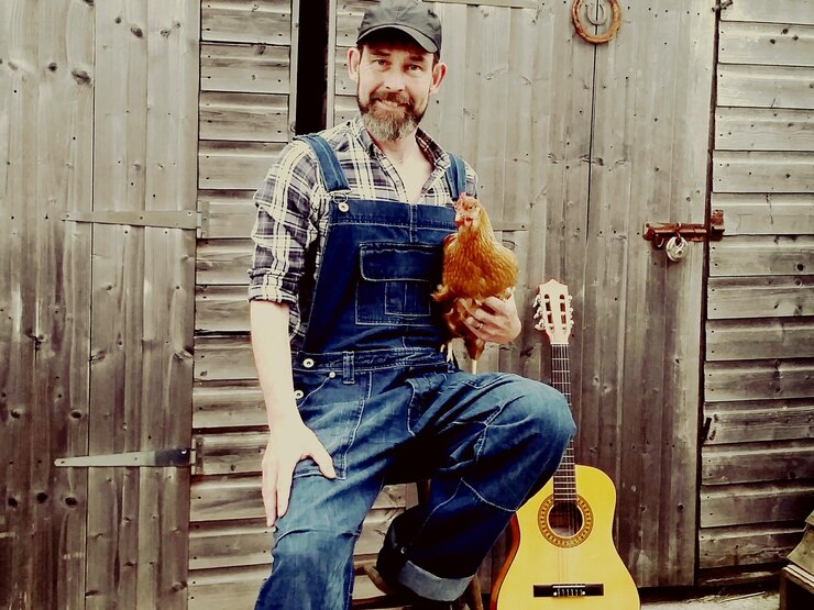 Foto retrato de um homem segurando uma galinha em uma fazenda