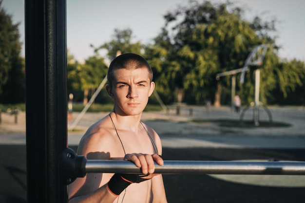 Retrato de um homem sem camisa de pé junto ao corrimão