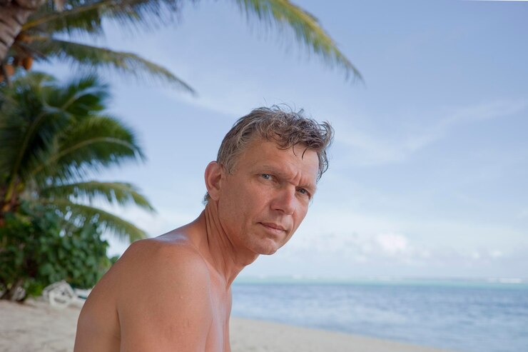 Foto retrato de um homem sem camisa pelo mar contra o céu