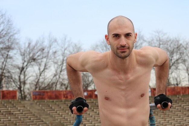 Foto retrato de um homem sem camisa se exercitando contra o céu