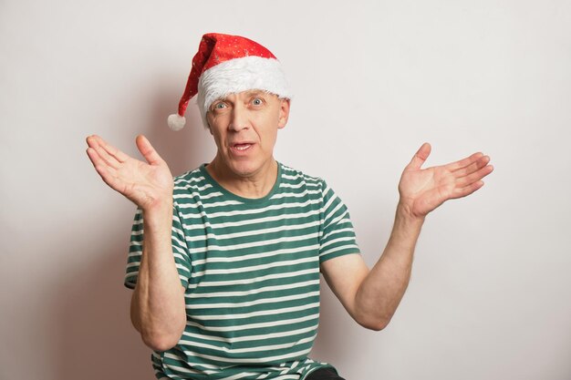 Retrato de um homem sênior com um chapéu de Papai Noel em um espaço de cópia de fundo branco