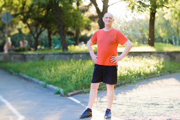 Retrato de um homem sênior feliz e ativo posando depois de se exercitar ao ar livre