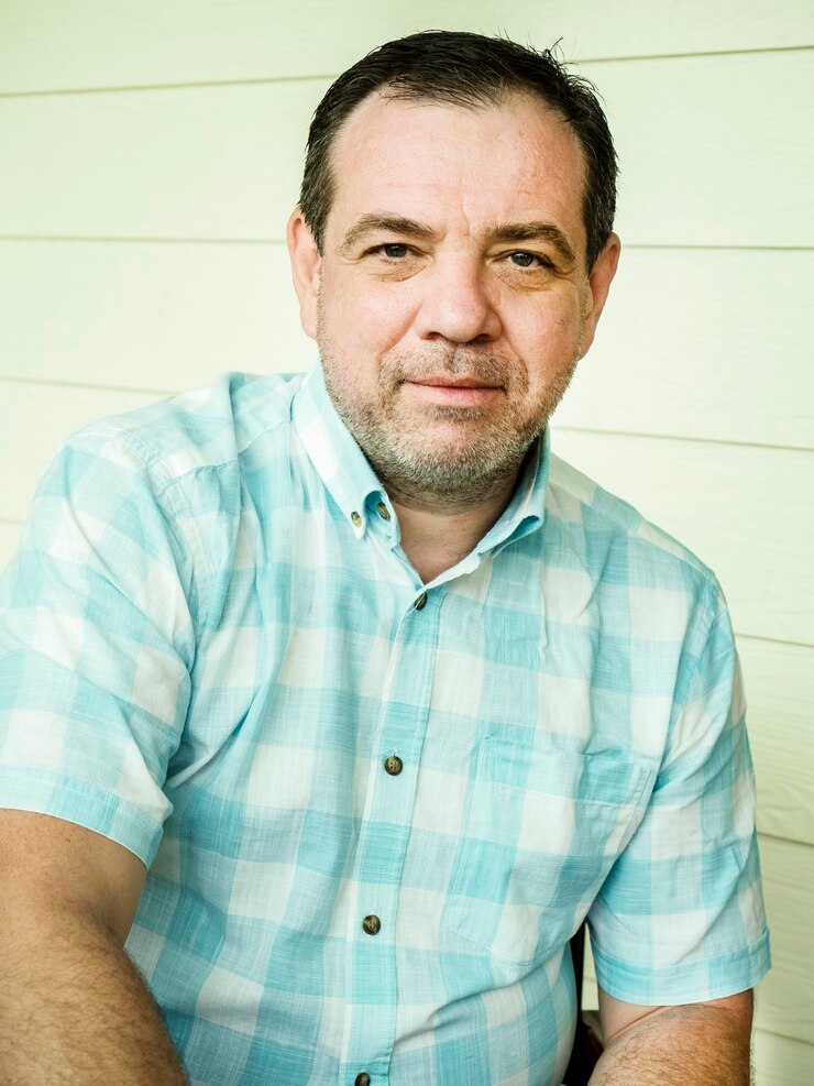 Foto retrato de um homem sentado contra a parede