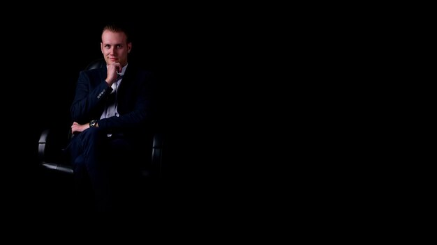 Foto retrato de um homem sentado no escuro